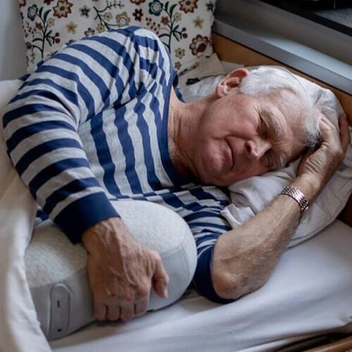 Oudere man in bed met de Somnox Slaaprobot
